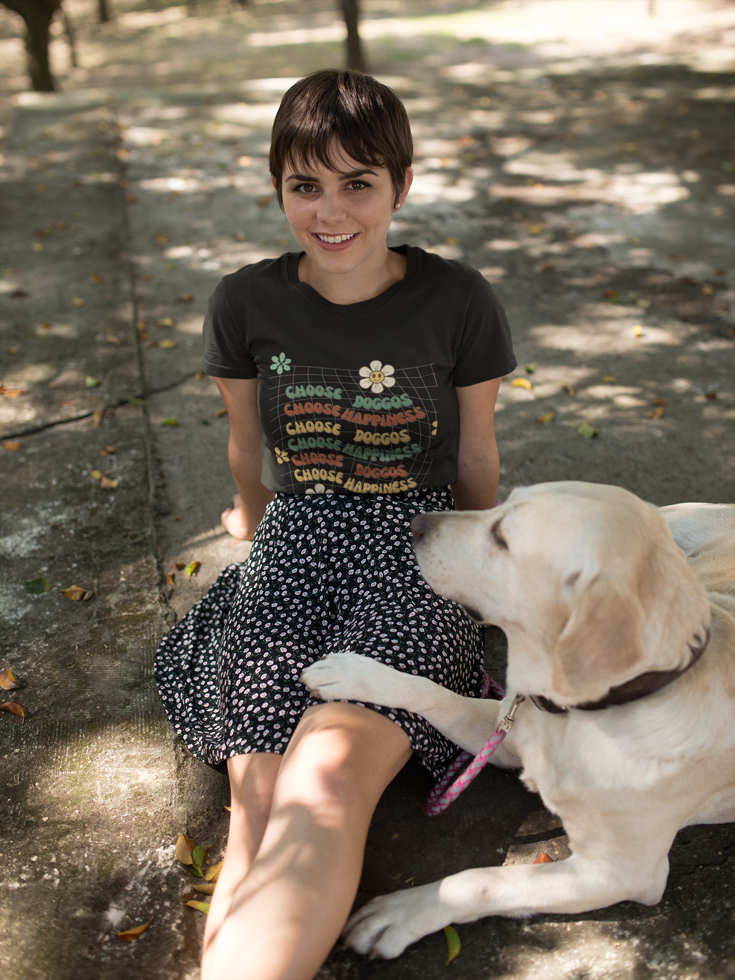 Dog mom wearing t-shirt that says choose doggos choose happiness sitting with her dog